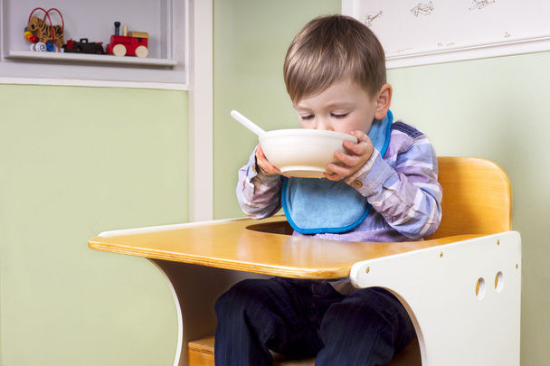 Lindo niño comiendo de un tazón
 - Foto, Imagen