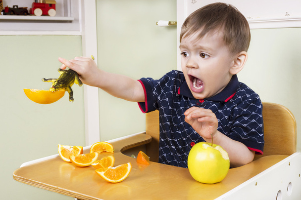 Pequeño niño jugando con su fruta
 - Foto, Imagen