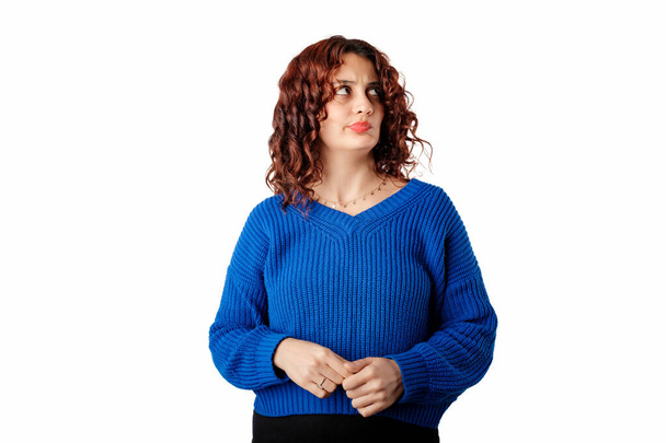 Linda mujer caucásica con suéter de jersey azul aislado sobre fondo blanco mirando el espacio de copia vacío. Deben estar haciendo planes astutos. Pensando con cara seria. - Foto, imagen