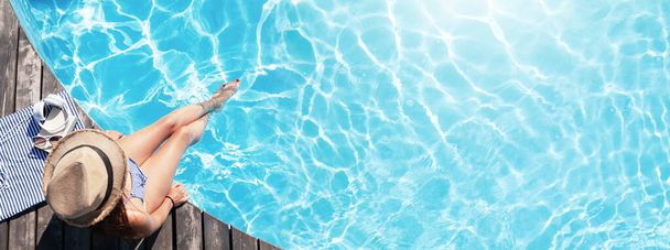 Havuzun yanındaki tahta güvertede bir kadın var. Yaz tatili - Fotoğraf, Görsel