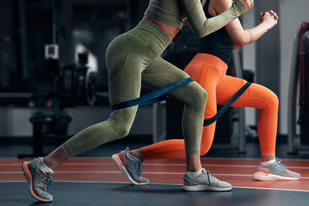 Mulheres esportivas no ginásio exercitando com elástico elástico elástico de resistência. - Foto, Imagem