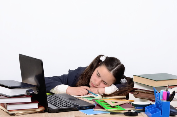 Estudante adolescente cansado de treinamento e dormiu com a cabeça na mesa da escola perto do computador
 - Foto, Imagem