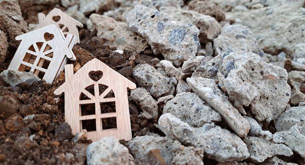 Piccole case in legno a terra e pietre, concetto terremoto 2023. Copia spazio  - Foto, immagini