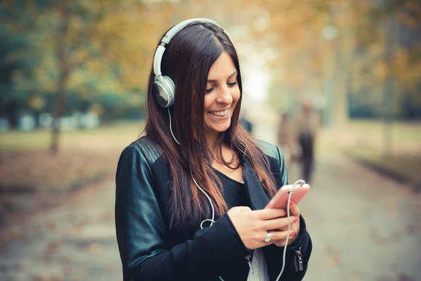 Young girl in park listening music - Photo, Image