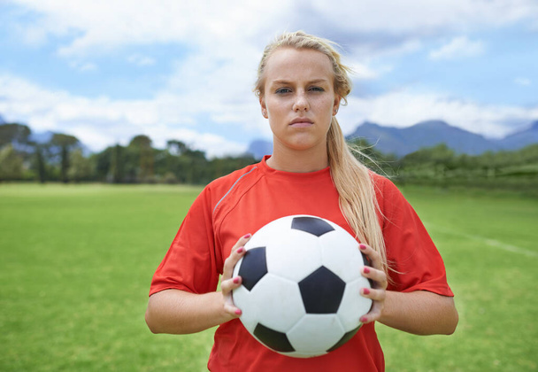 Getting focused for the game. Portrait of a determined young female soccer player standing on the pitch - Foto, Bild