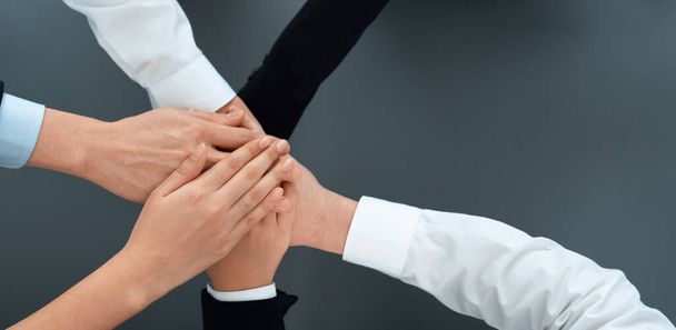 Top view partial hands wearing formal suit joining stack and form circle as symbol of team building, unity and harmony in office workplace. Successful business team of synergy holding hand together. - Φωτογραφία, εικόνα