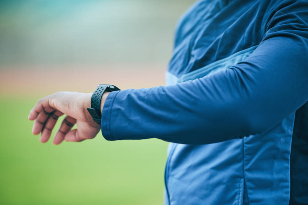 Time, watch and hand of a fitness man watching fitness, run and training results on a smartwatch. Workout tech, sports and exercise app monitor outdoor with an athlete with blurred background. - Valokuva, kuva