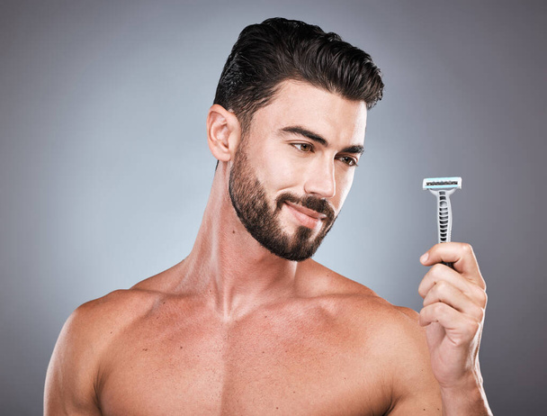 Face, shaving product and man with razor in studio isolated on a gray background. Epilation, haircare and thinking male model with facial tool to shave for wellness, health hygiene and hair removal - Foto, imagen