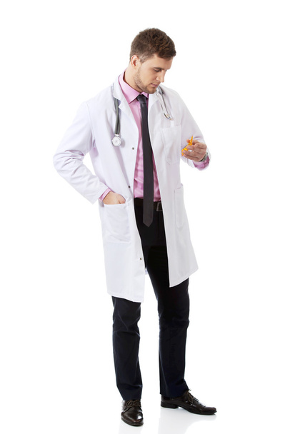 Male doctor holding pills. - Foto, imagen