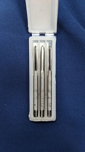 a machine tapering tool set used for drilling and threading of mechanical components of different size kept in a box isolated  - Photo, Image