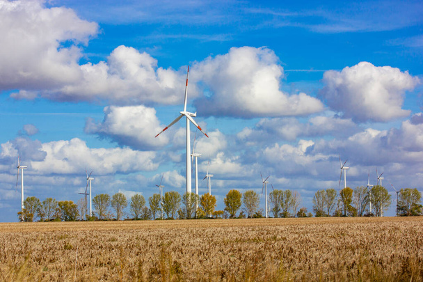 風力タービン、青い空に対してフィールドに巨大なプロペラを持つ風車。持続可能性、グリーンエネルギーの概念。代替電源。風力発電設備。ヨーロッパの風力発電所.  - 写真・画像