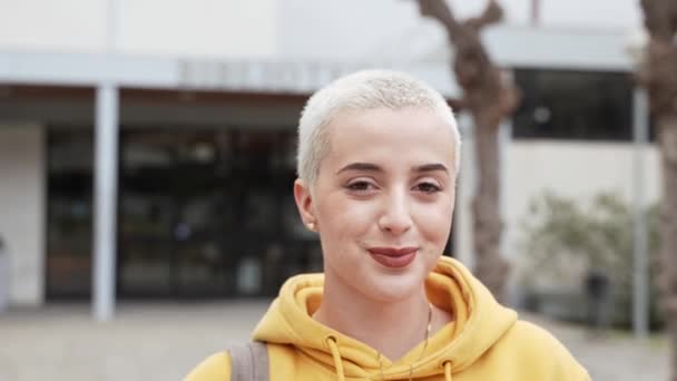 Žena University Student s blond krátce oholené vlasy Usmívající se - Portrét Mladá Trendy Žena - Záběry, video