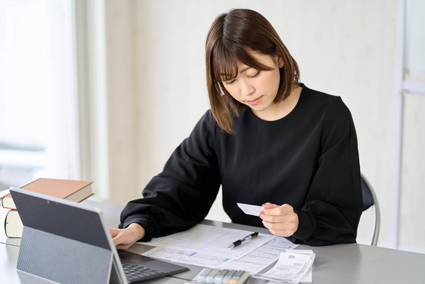 Азійська жінка вводить витрати в бухгалтерське програмне забезпечення - Фото, зображення