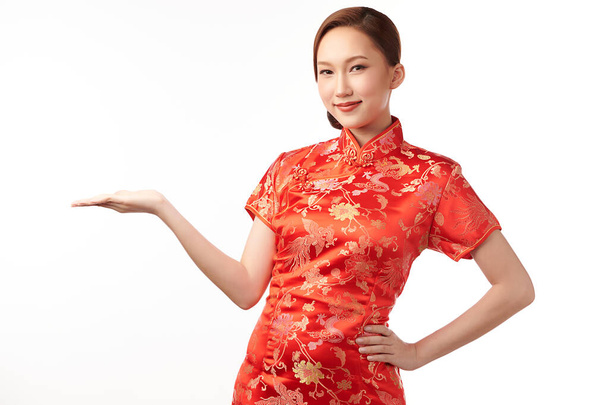 Happy Chinese new year, Beautiful young Asian woman wearing traditional cheongsam qipao dress with gesture of introduce isolated on white background, - Foto, Bild