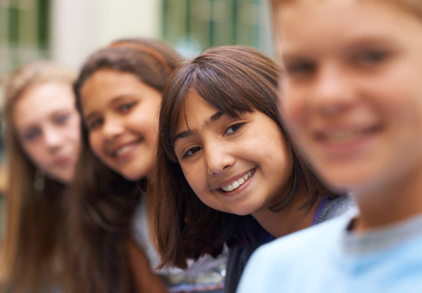 Uśmiecha się do przyjaciół. Portret młodej uczennicy stojącej wśród przyjaciół - Zdjęcie, obraz