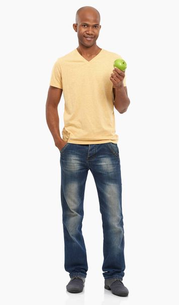 Zdrowy wybór. Studyjne ujęcie przystojnego Afroamerykanina trzymającego jabłko - Zdjęcie, obraz