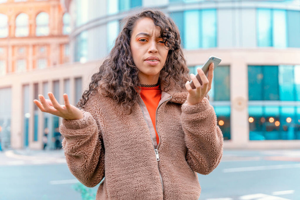 Outdoor portrait of an upset woman using a mobile phone visiting a Europe city - Fotó, kép