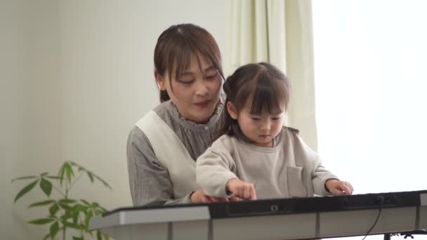 Parents and children practicing playing the piano - Filmmaterial, Video