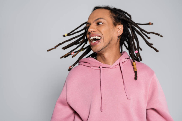 positive multiracial man with dreadlocks shaking head and smiling isolated on grey  - Foto, Imagem