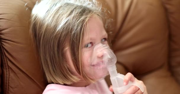 Little girl uses nebulizer at home. Children asthma inhaler and nebulizer vapor - Filmati, video