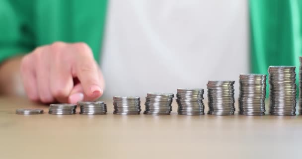 Бізнес-леді пальцями рахують стопки монет. Збільшення доходів і прибутку і заробітку
 - Кадри, відео