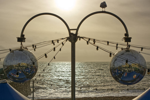 Δύο αστραφτερές μπάλες πάνω από εστιατόριο μπροστά στη θάλασσα στο Brighton, East Sussex, Αγγλία. - Φωτογραφία, εικόνα