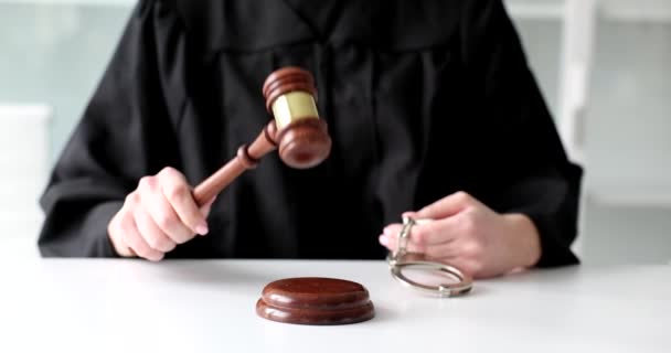 Judge knocks on gavel in the courtroom and holds out the handcuffs. Justice law legal system and crimes - Záběry, video