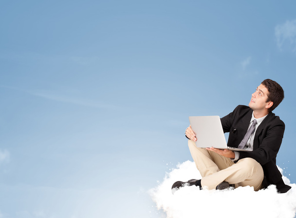 Attractive businessman sitting on cloud with copy space - Photo, Image