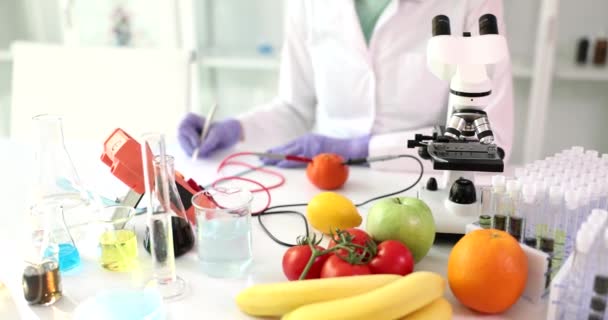 Lo scienziato analizza frutta e verdura coltivate in laboratorio utilizzando un dispositivo. Microbiologo che lavora con il cibo in laboratorio moderno - Filmati, video
