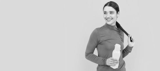 Γυναίκα απομονωμένη προσωπογραφία, πανό με χώρο αντιγραφής. χαρούμενο νεαρό κορίτσι κατέχει σπορ μπουκάλι με νερό, υγεία - Φωτογραφία, εικόνα