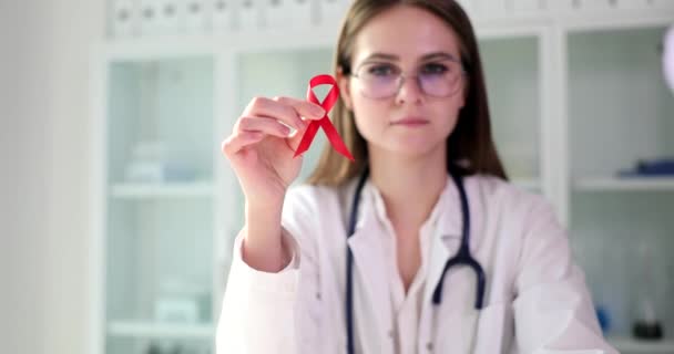 Immunologe für Infektionskrankheiten mit einer roten Schleife in der Hand bei HIV. Prävention und Behandlung von AIDS und HIV - Filmmaterial, Video
