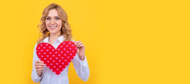 glad woman with red love heart on yellow background. Woman isolated face portrait, banner with mock up copy space - Photo, Image