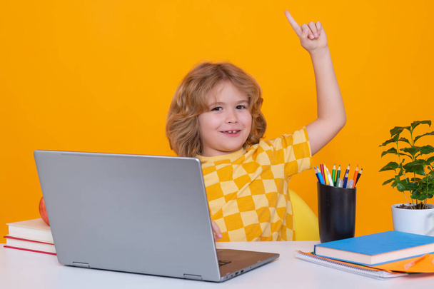 School kid holding index finger up with great new idea. School child using laptop computer - Foto, Imagen