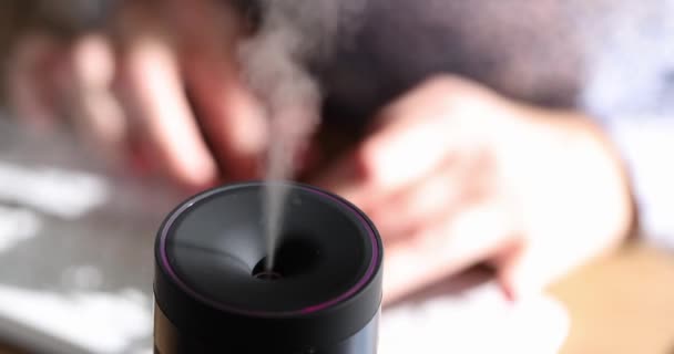 Humidifier with aroma oil diffuser on table. Steam from a humidifier and air humidification in an apartment or office - Materiał filmowy, wideo