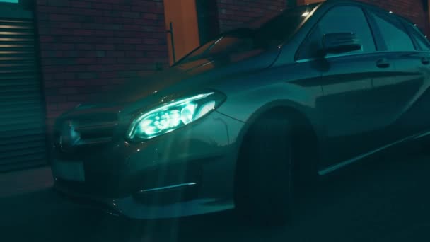 Silhouette of beautiful car on smoked dark background . Car lights on fog - Filmati, video