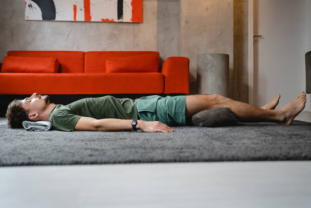 Un hombre caucásico moderno adulto practica yoga restaurativo masculino en casa - Foto, imagen