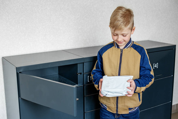 Mail shipping concept and online shopping. Boy client using automated self service post terminal machine or locker - Foto, Imagem