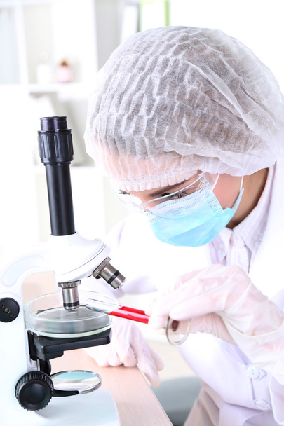 γυναίκα επιστήμονας που χρησιμοποιεί μικροσκόπιο στο εργαστήριο - Φωτογραφία, εικόνα