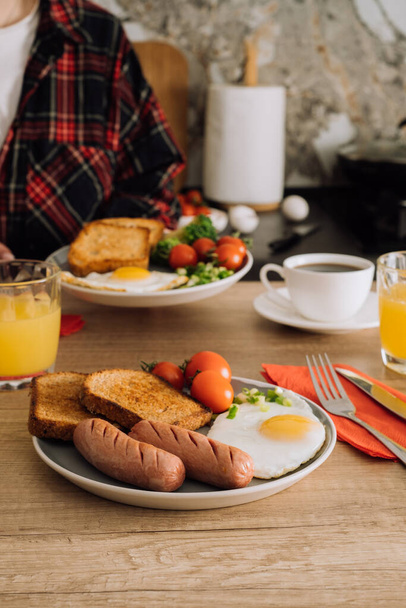 Μαγειρεμένα αγγλικά πρωινό με καφέ και χυμό πορτοκαλιού στην κουζίνα στο σπίτι - Φωτογραφία, εικόνα
