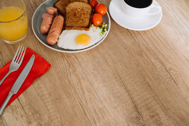 Αγγλικό πρωινό με μαύρο καφέ και χυμό πορτοκάλι σε ξύλινο τραπέζι με χώρο αντιγραφής - Φωτογραφία, εικόνα