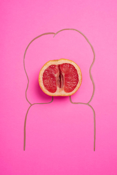a grapefruit, grapefruit on a pink background and the silhouette of a drawn woman, concept of female health, healthy vagina, no people - 写真・画像