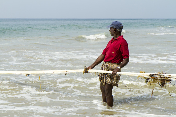 Fisherman pulling a fishing net from the Arabian Sea - 写真・画像