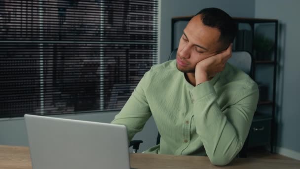 Tired lazy young african american businessman bored at work fall asleep at office desk sleepy overworked ethnic man employee sleeping at workplace near laptop napping resting feel exhaustion fatigue - Metraje, vídeo