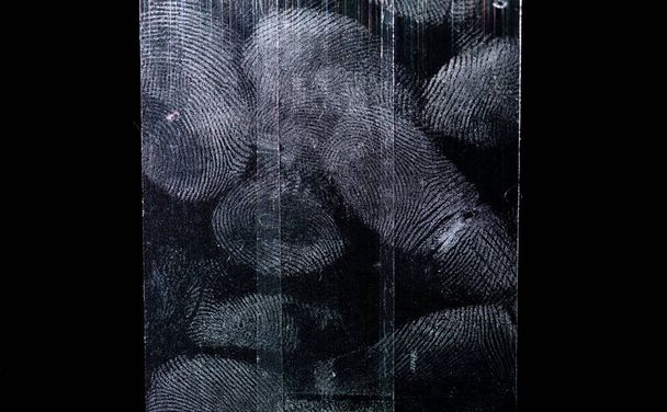 Tinta dita su nastro adesivo trasparente o strisce isolate su sfondo nero - Foto, immagini