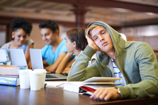 Школа отстой. Молодой студент выглядит скучающим в своей учебной группе - Фото, изображение