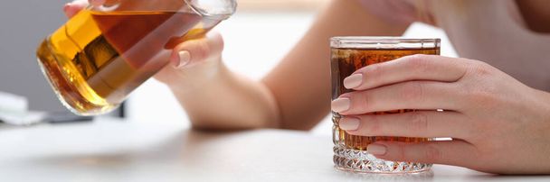 Woman drinks alcohol cognac or whiskey alone. Alcohol abuse or drinking concept - Foto, Imagen