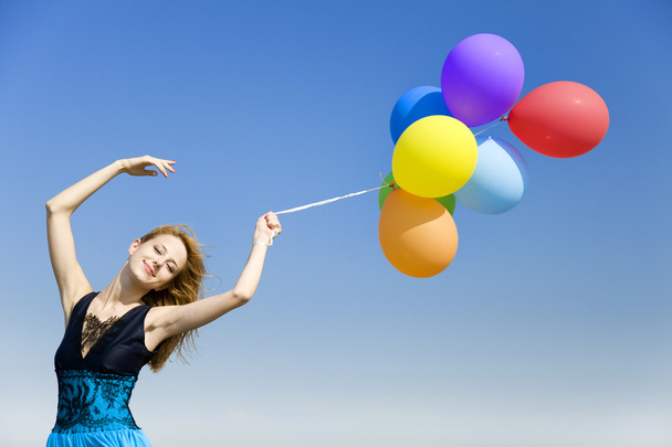 Redhead girl with colour balloons at blue sky background. - Fotografie, Obrázek