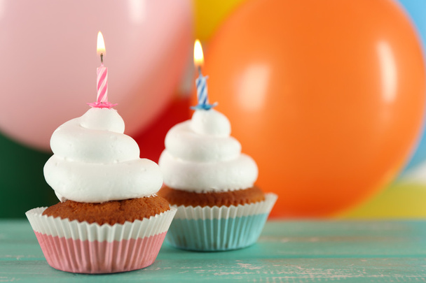 Deliciosos cupcakes de cumpleaños en la mesa sobre un fondo brillante
 - Foto, imagen