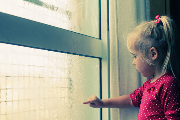 Little girl looking through window - Photo, Image