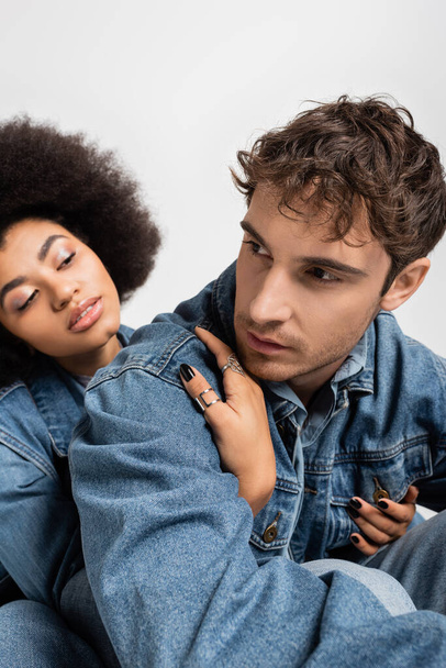 african american woman hugging good looking man in denim clothes isolated on grey  - Fotografie, Obrázek